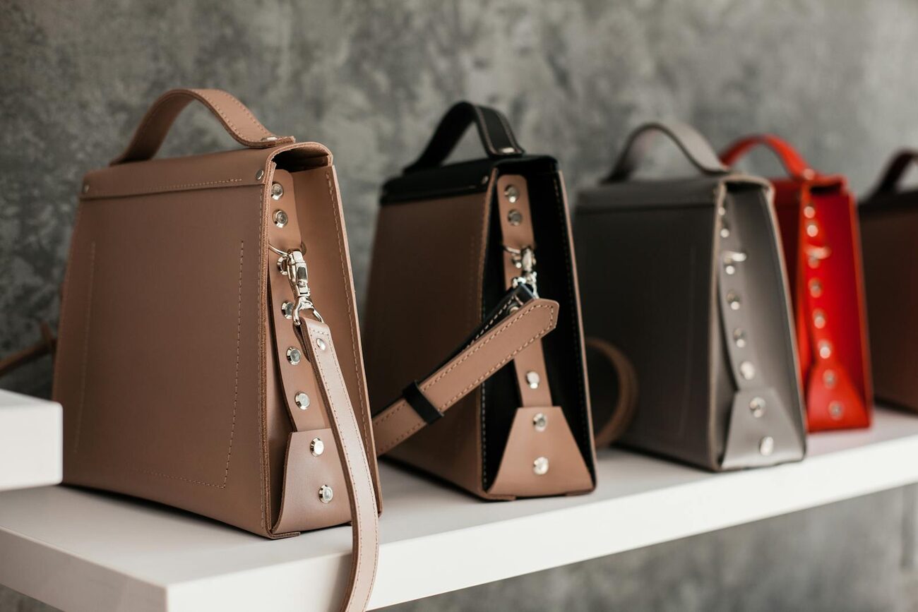 A row of designer leather handbags