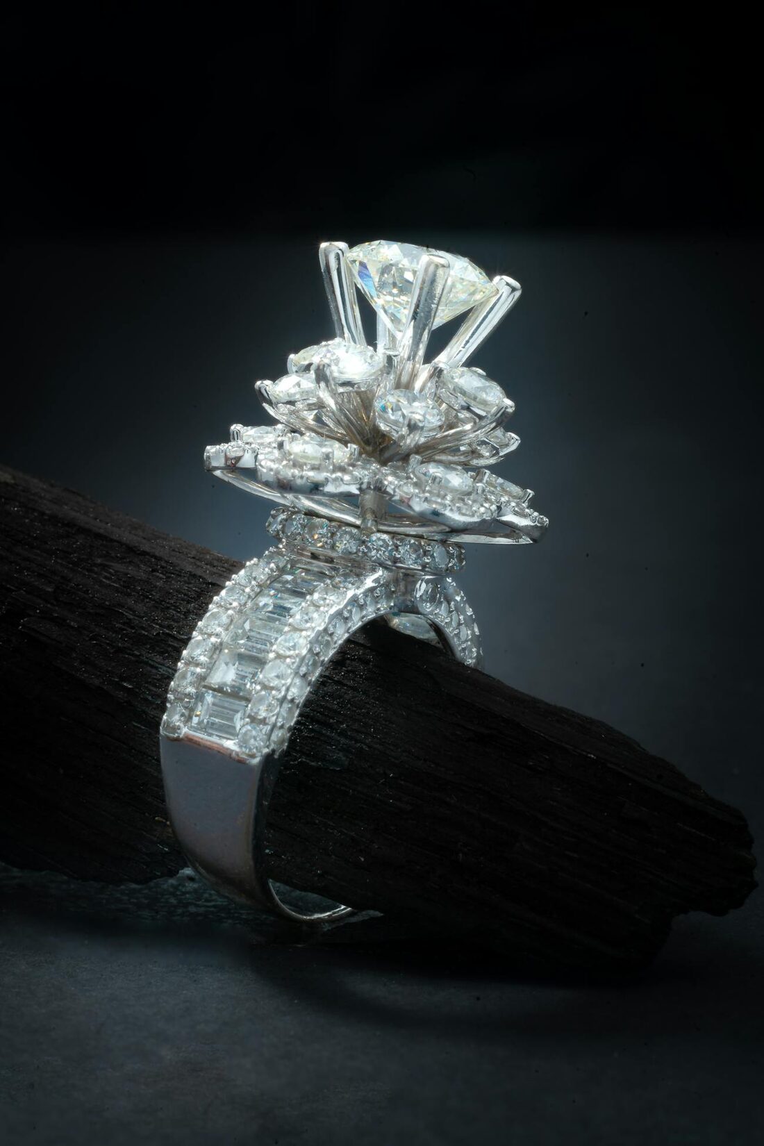 A diamond ring photographed on a dark background